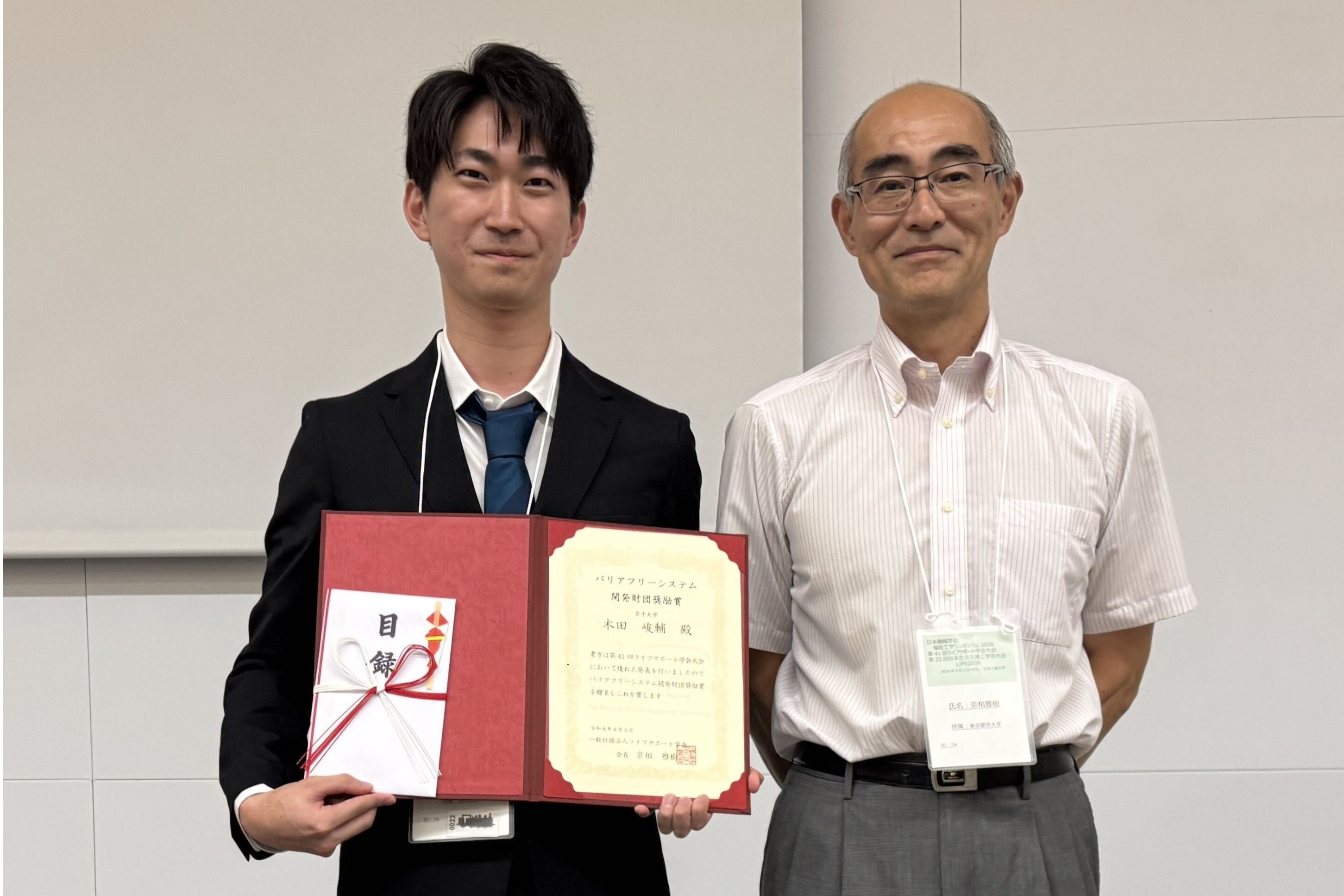 受賞した木田峻輔さん（左）と，ライフサポート学会会長 京相雅樹先生（右）